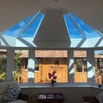 A bright sunroom in West Sussex with white walls and large uPVC windows.