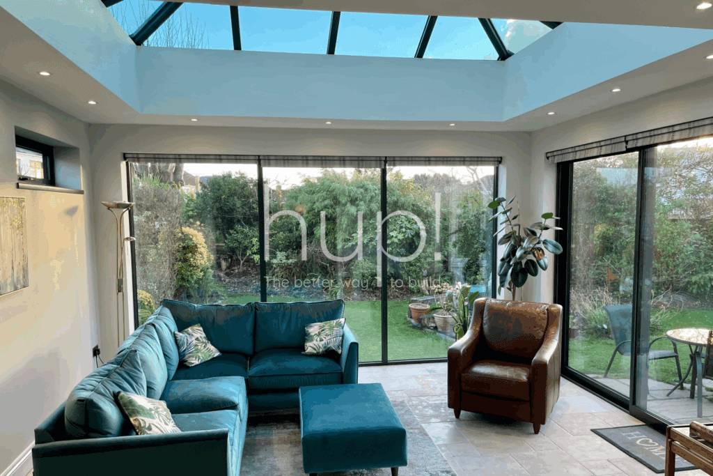 hup conservatory, A bright sunroom with a uPVC glass roof, large sliding glass doors and lush green plants—looking out onto a garden in West Sussex.
